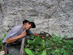 Pusharo, Sector A I-A (detalle). Hermogenes Figueroa Lucana muestra una parte de la base de la pared principal. Numerosas figuras están hoy bajo del nivel actual del suelo. (Foto: Thierry Jamin, agosto de 2006)